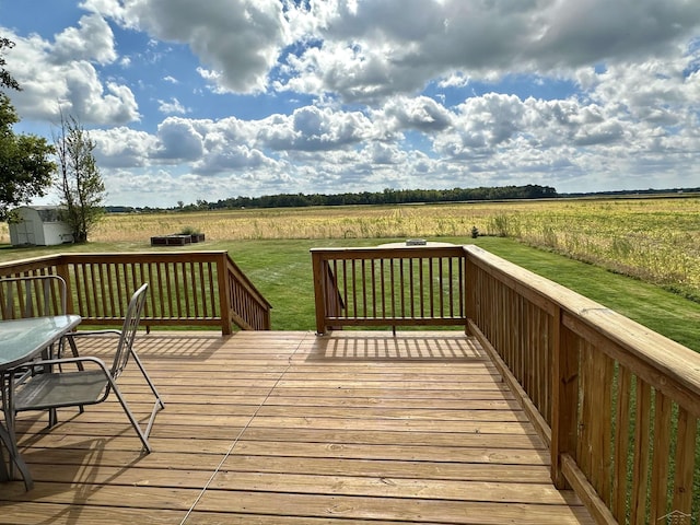 wooden terrace featuring a rural view and a lawn