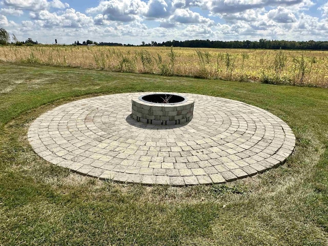 view of yard featuring a rural view, an outdoor fire pit, and a patio