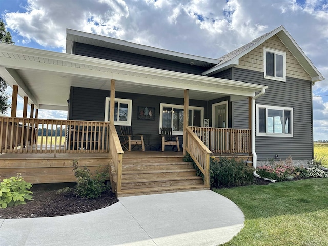 view of front of home with a porch and a front lawn