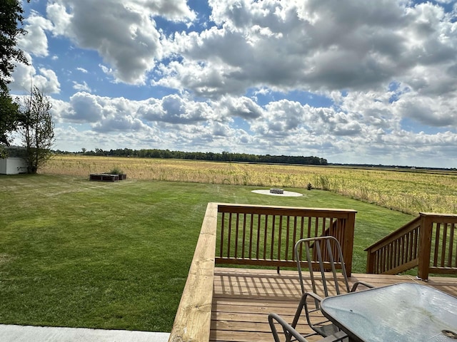 deck featuring a lawn and a rural view