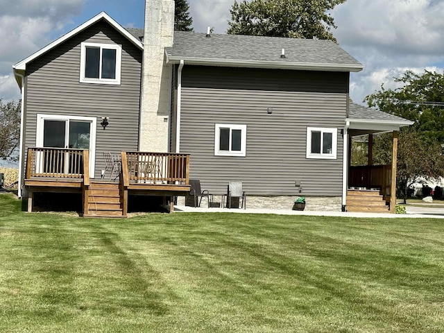 rear view of house with a lawn and a deck