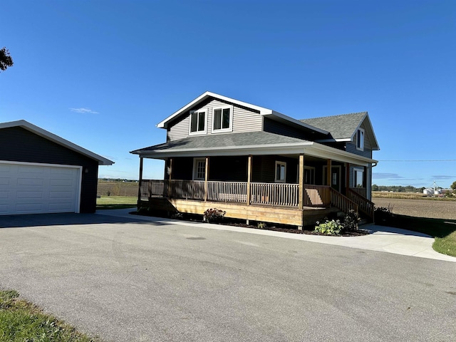 farmhouse featuring an outbuilding, a garage, and covered porch