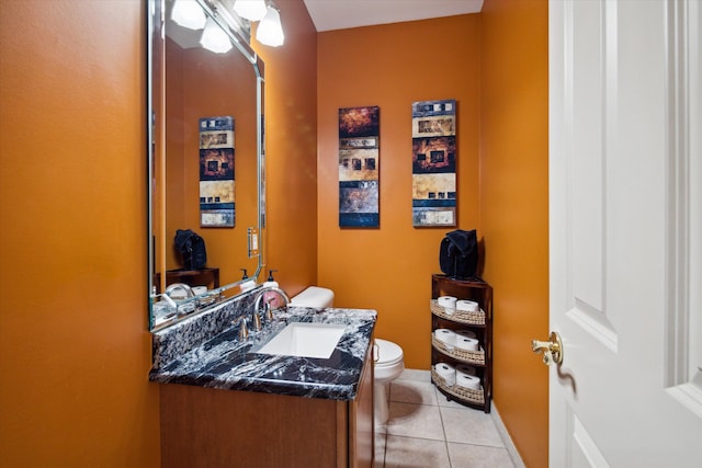 bathroom with toilet, vanity, and tile patterned floors