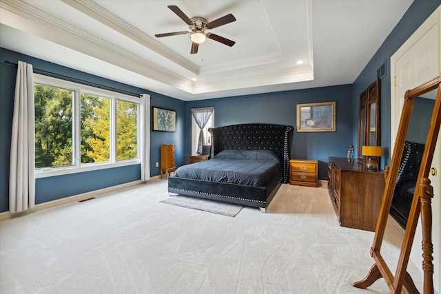 carpeted bedroom with ceiling fan, a raised ceiling, and crown molding