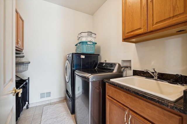 washroom with washer and clothes dryer, cabinets, light tile patterned floors, and sink