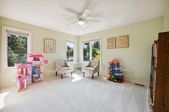 recreation room featuring light colored carpet and ceiling fan