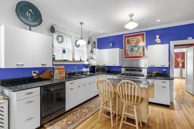 kitchen featuring appliances with stainless steel finishes, decorative light fixtures, light hardwood / wood-style flooring, white cabinets, and a kitchen island