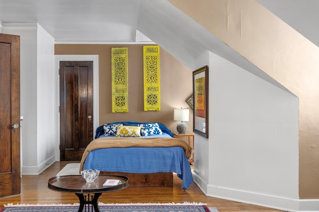 bedroom featuring wood-type flooring and crown molding