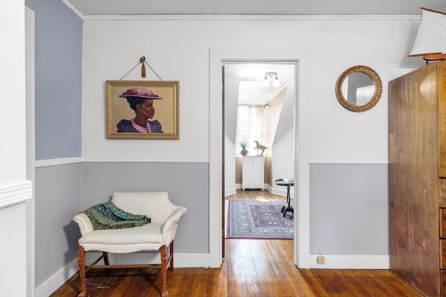 living area featuring crown molding and hardwood / wood-style flooring