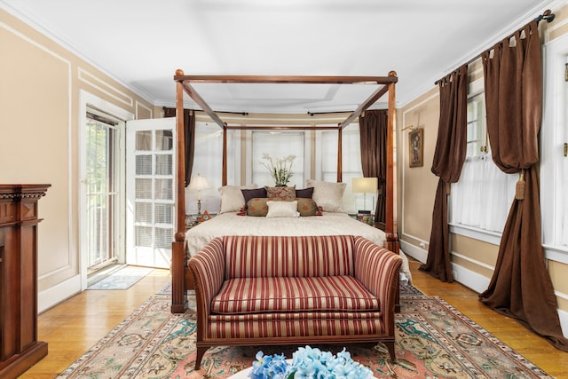 bedroom featuring crown molding, access to outside, and light hardwood / wood-style flooring