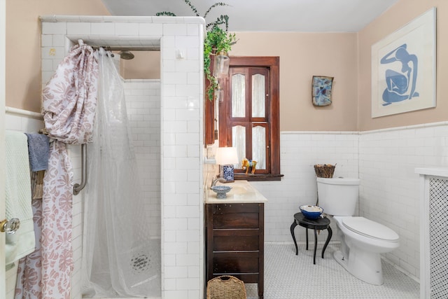 bathroom with curtained shower, tile patterned floors, toilet, vanity, and tile walls