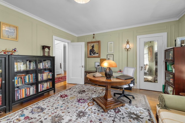 sitting room with hardwood / wood-style flooring and crown molding