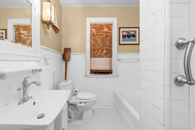 bathroom with tile patterned floors, toilet, tile walls, and sink