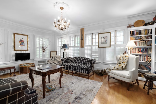 living room with light hardwood / wood-style floors, ornamental molding, and a wealth of natural light