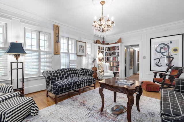 living room featuring light hardwood / wood-style flooring, a notable chandelier, and ornamental molding