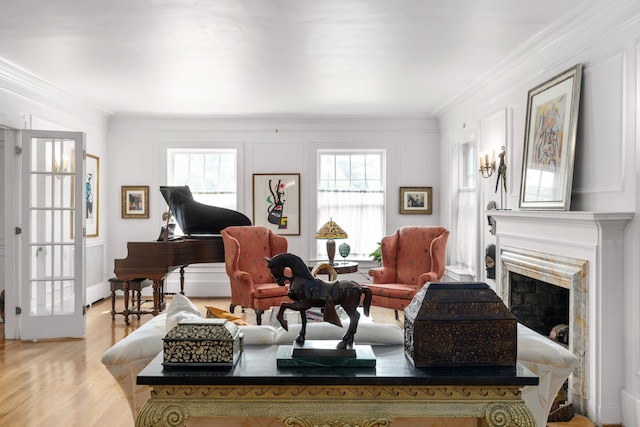 living room featuring a fireplace, crown molding, and light hardwood / wood-style flooring