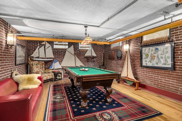 playroom with hardwood / wood-style floors, brick wall, and pool table