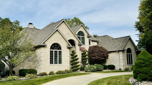 french country inspired facade featuring a front lawn