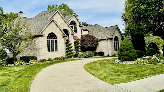 french country inspired facade featuring a front lawn