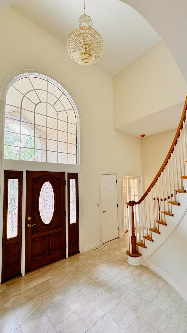 foyer featuring a high ceiling and a notable chandelier