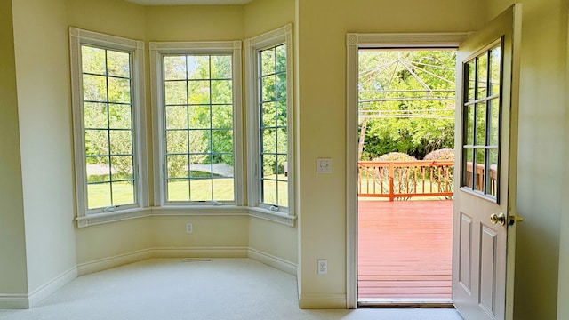 entryway with light colored carpet and a healthy amount of sunlight