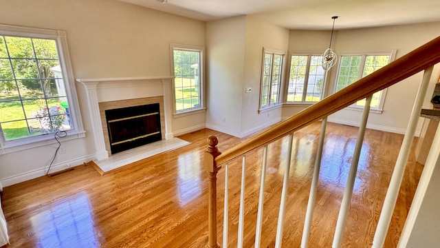 staircase featuring hardwood / wood-style flooring, plenty of natural light, and a chandelier