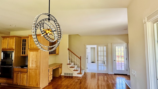 foyer featuring built in desk, dark wood-type flooring, and french doors