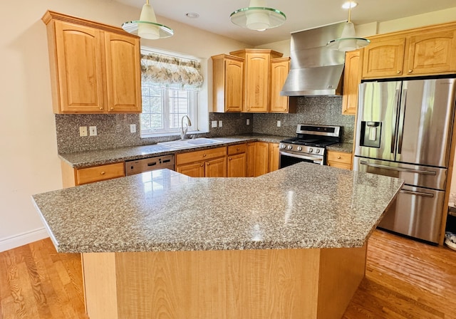 kitchen with wall chimney range hood, sink, a kitchen island, light hardwood / wood-style floors, and stainless steel appliances