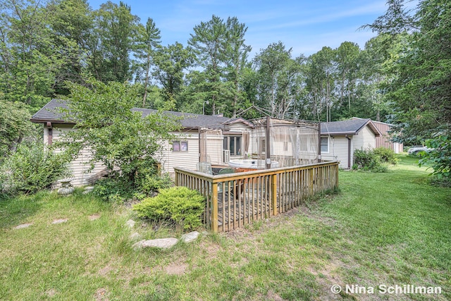 rear view of property featuring a lawn and a wooden deck