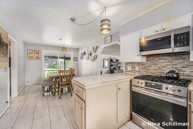 kitchen with decorative backsplash, appliances with stainless steel finishes, and decorative light fixtures