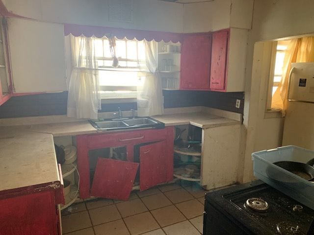 kitchen with light tile patterned floors, a wealth of natural light, and sink