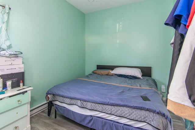 bedroom with a baseboard radiator and light wood-type flooring