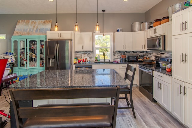 kitchen featuring stainless steel appliances, white cabinetry, light hardwood / wood-style floors, and sink