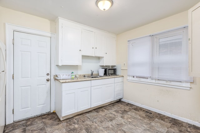 kitchen featuring white cabinetry and sink