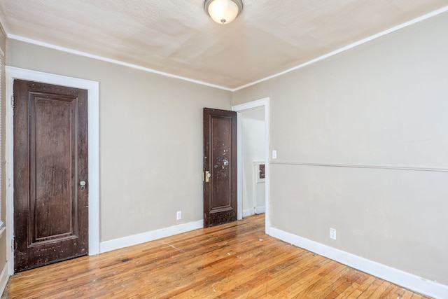 unfurnished room featuring crown molding and light hardwood / wood-style floors