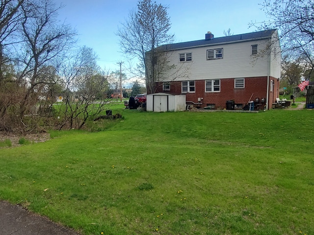 rear view of property featuring a storage shed and a yard