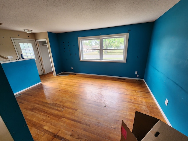 unfurnished living room featuring hardwood / wood-style floors, a textured ceiling, and plenty of natural light