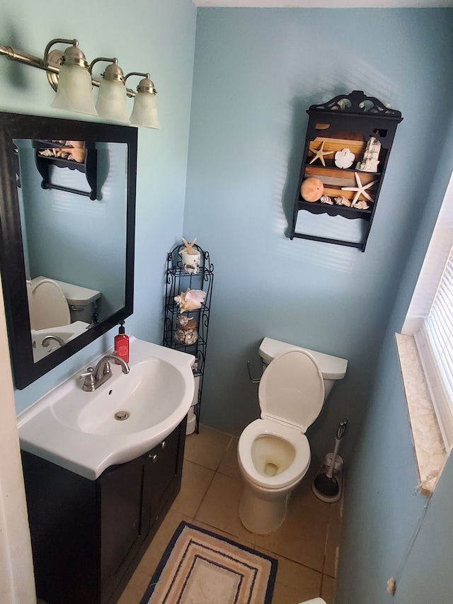 bathroom with tile patterned flooring, vanity, and toilet