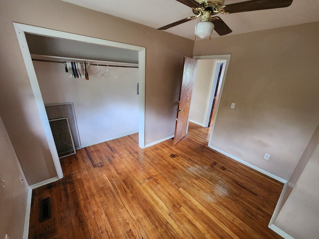 unfurnished bedroom with ceiling fan, a closet, and wood-type flooring