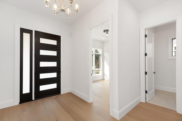 foyer entrance featuring hardwood / wood-style flooring and a notable chandelier