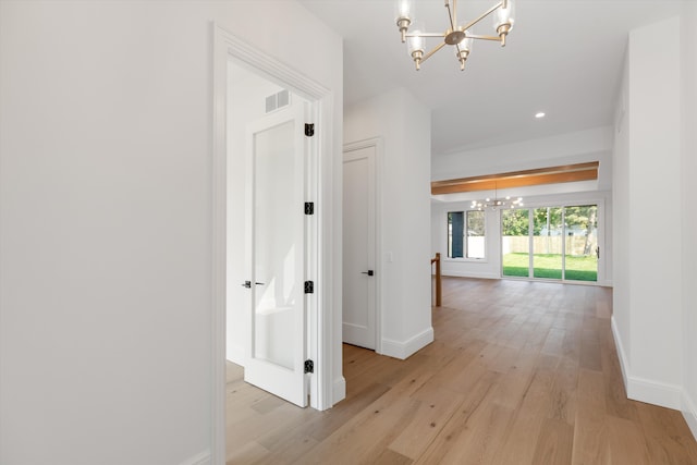 hall with a chandelier and light hardwood / wood-style flooring