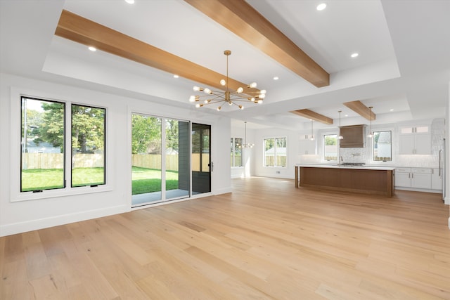 unfurnished living room featuring a notable chandelier, beam ceiling, and light wood-type flooring