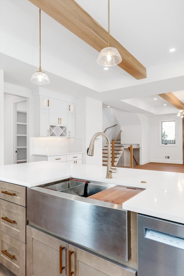 kitchen with beam ceiling, dishwasher, sink, decorative light fixtures, and white cabinets