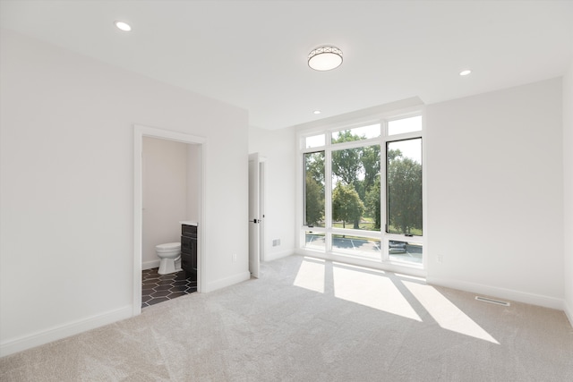 unfurnished bedroom featuring carpet and ensuite bathroom