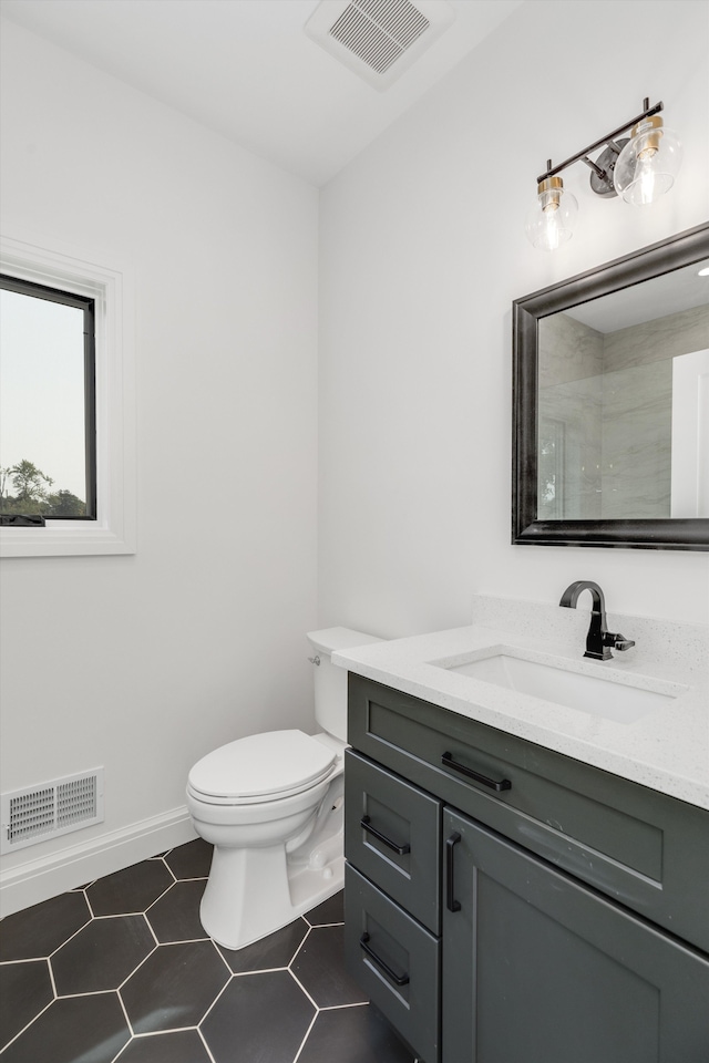 bathroom with tile patterned flooring, vanity, and toilet