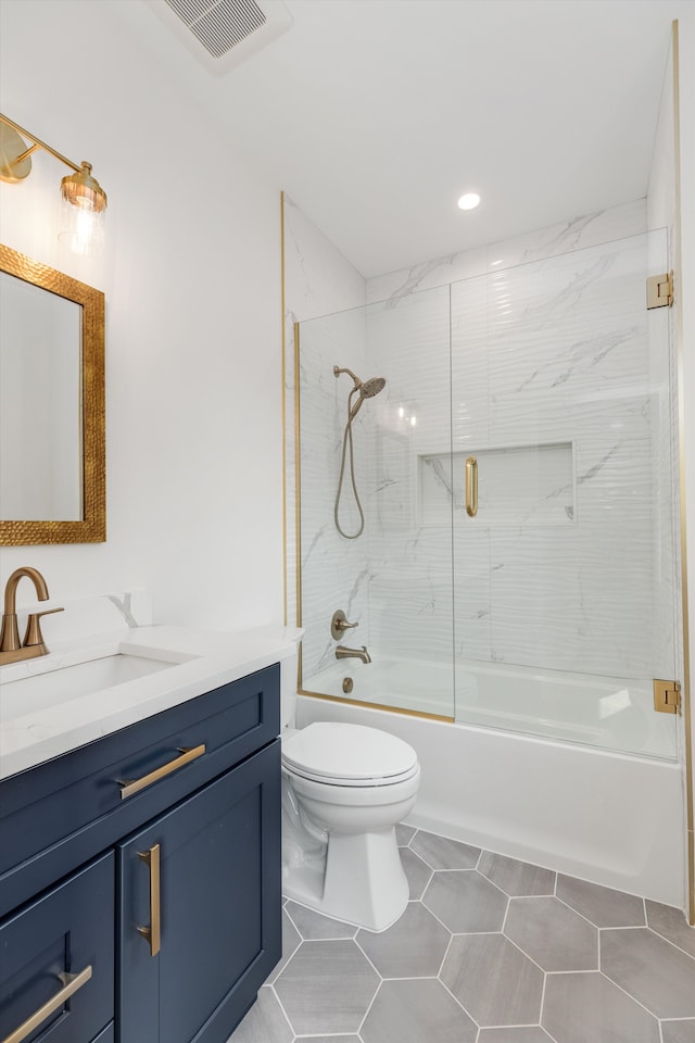 full bathroom with tile patterned floors, shower / bath combination with glass door, vanity, and toilet