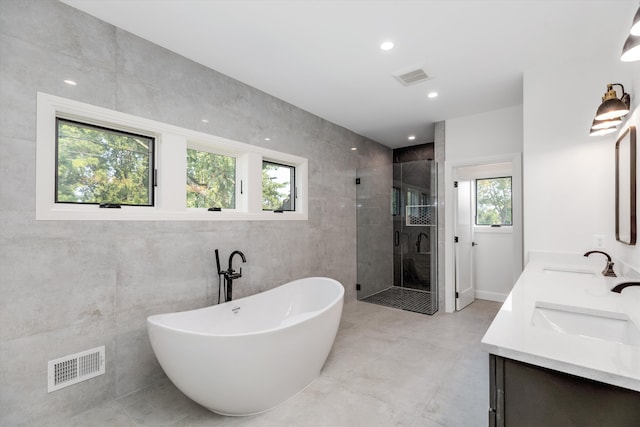 bathroom featuring vanity, tile walls, and a healthy amount of sunlight