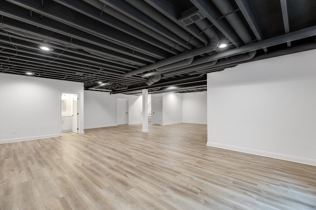 basement with light hardwood / wood-style flooring