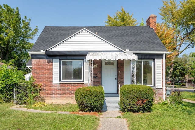 bungalow-style home with a front yard