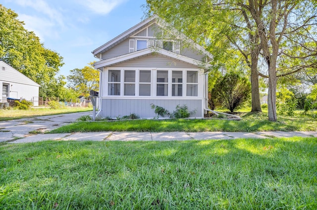 view of home's exterior featuring a yard and a sunroom